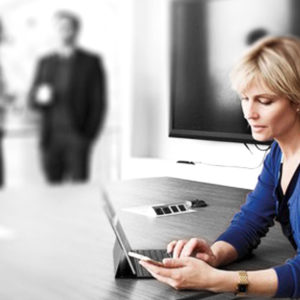 Blonde woman watching her phone in a meeting room